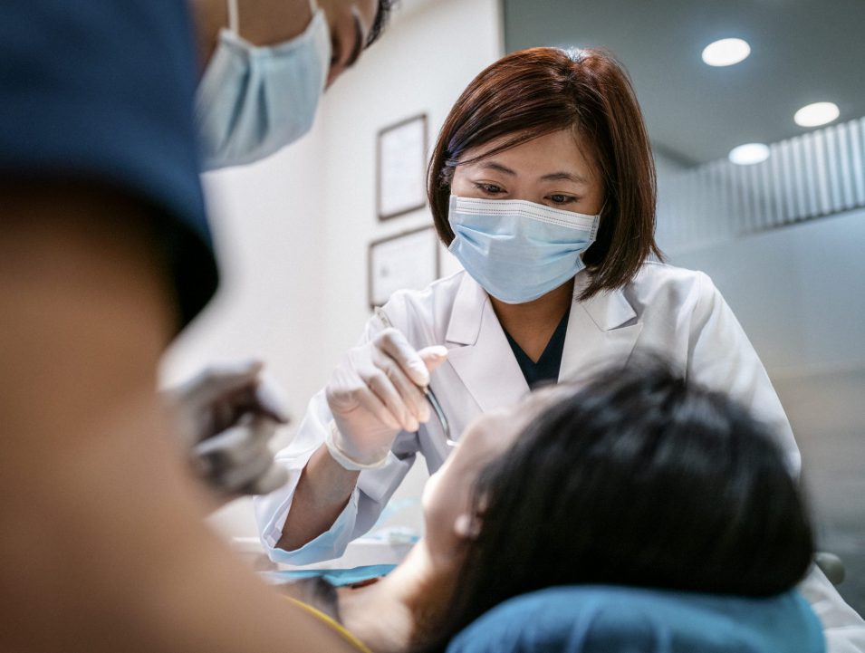 Dentist with male assistant perfornming a root canal in Brantford on female patient