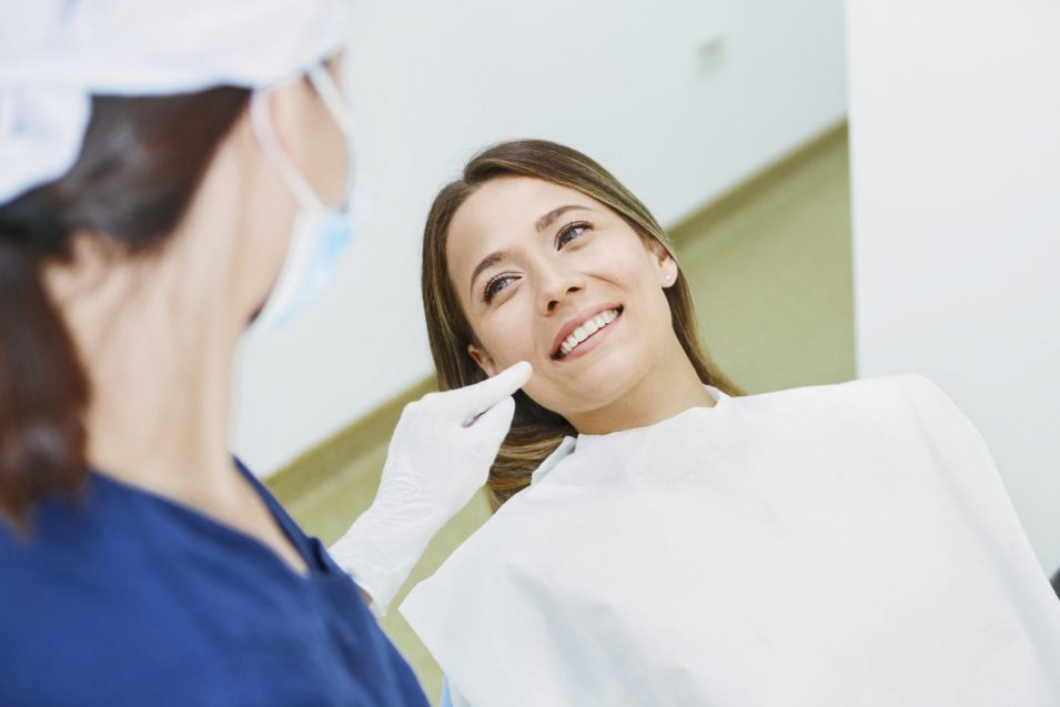 Female dentist talking to a patient explaining gum grafting general dentistry in Brantford