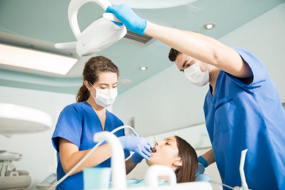 Dentist With Male Colleague Treating Patient with a root canal in Brantford At Clinic"