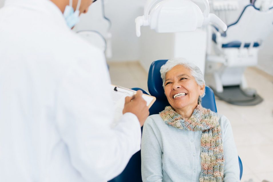 Happy senior patient smiling at male dentist