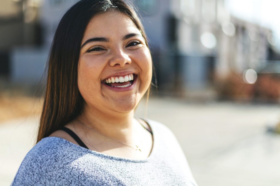 Attractive Generation Z Young Woman of Hispanic Ethnicity Smiling for a Portrait Young women achieved whiter teeth after treatment from cosmetic dentist