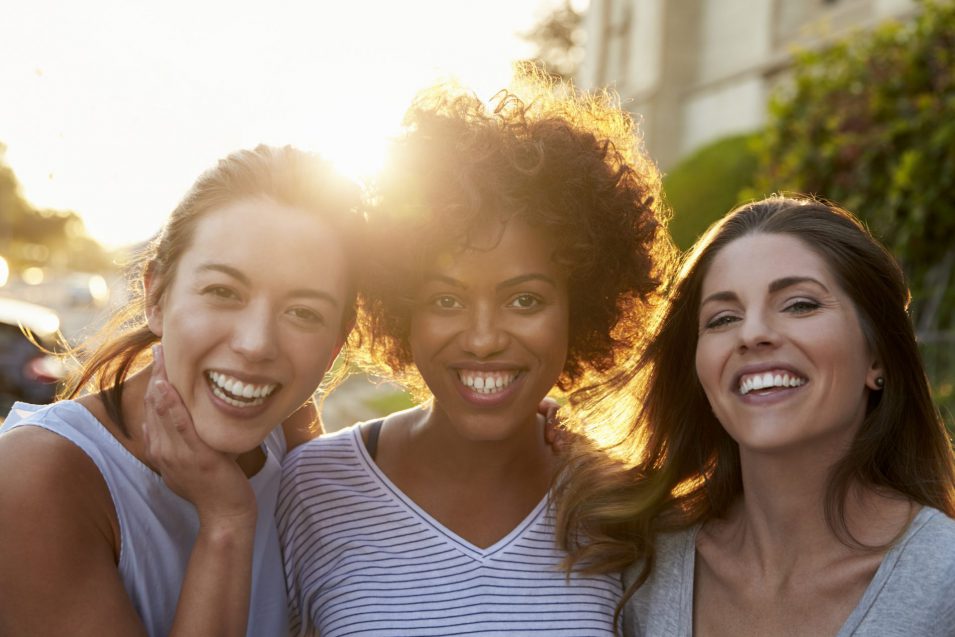 three young ladies in the street showing teeth after restorative dentistry in Brantford